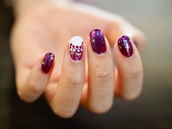 Cropped hand of woman showing painted fingernails