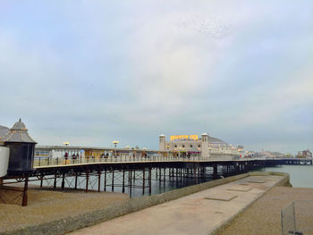 Pier over sea against sky in city