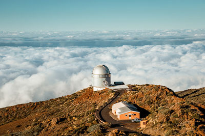 Largest optical reflecting telescope gran telescopio canarias located on grassy hilltop against cloudy sky at astronomical observatory on island of la palma in spain