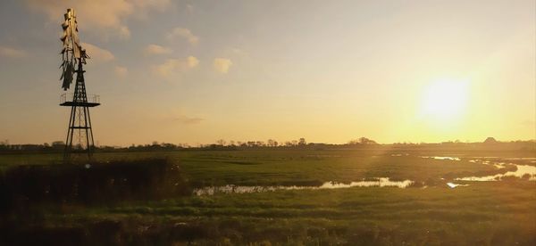 Scenic view of agricultural field against sky during sunset