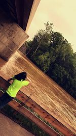 High angle view of boy on tree against sky