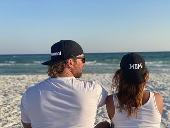 Rear view of people looking at sea against sky