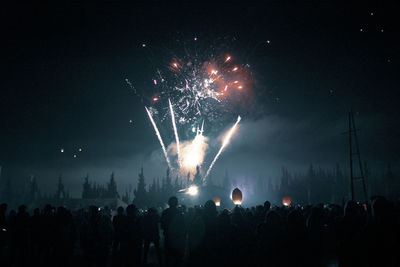 People watching firework display at night