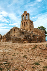 Low angle view of old building against cloudy sky
