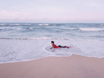 Woman on beach against sky