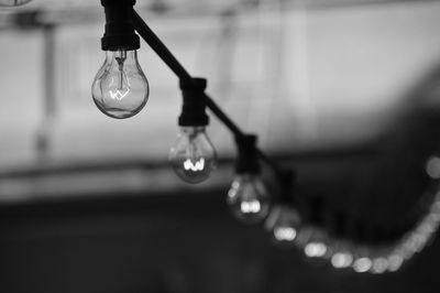 Close-up of light bulb hanging on cable