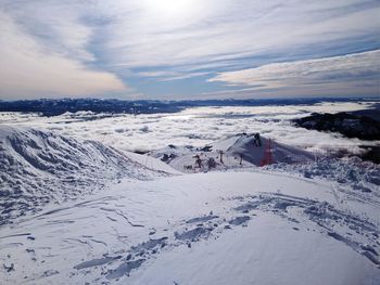 Snow covered landscape against sky