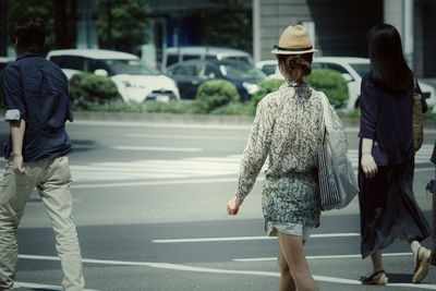 Rear view of people walking on road