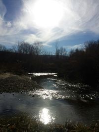 Scenic view of river against cloudy sky