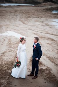 Rear view of couple walking on beach