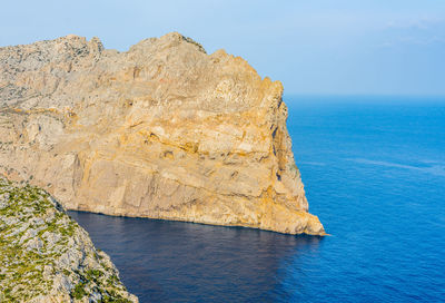 Scenic view of rock formation in sea against sky