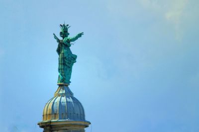 Low angle view of statue against blue sky