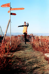 Full length of young woman standing on field