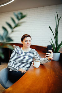 Portrait of young woman sitting on chair