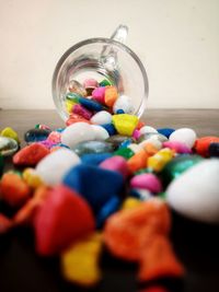 Close-up of multi colored candies in glass jar on table