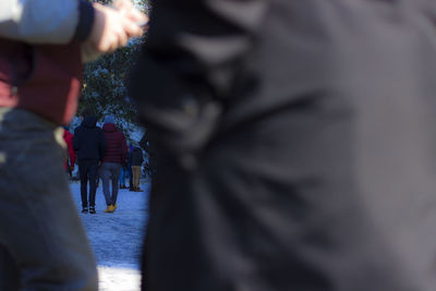 Rear view of people walking on road in winter