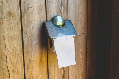 Close-up of toilet paper on wooden wall