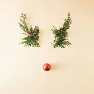 Reindeer face made of christmas decoration and pine branches. minimal christmas concept. flat lay.