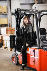 Woman sitting on forklift truck