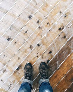 Low section of person standing on wooden floor