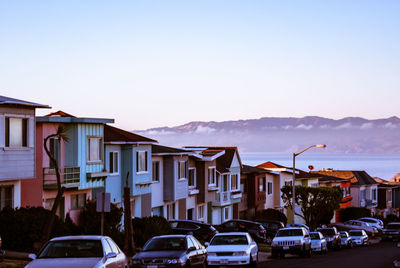 Cars on street amidst buildings in city against sky