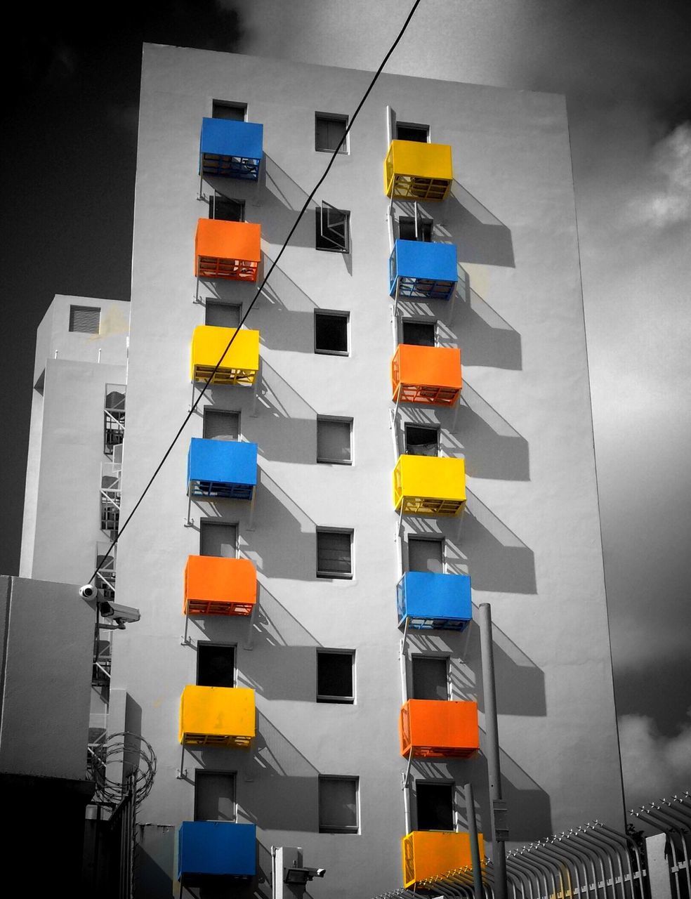 low angle view, architecture, building exterior, built structure, in a row, modern, building, multi colored, city, no people, residential building, repetition, window, day, sky, balcony, residential structure, blue, order, variation