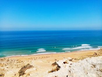 Scenic view of beach against clear blue sky