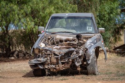 Abandoned wrecked car on field after car accident