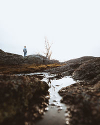 Man standing on shore against sky