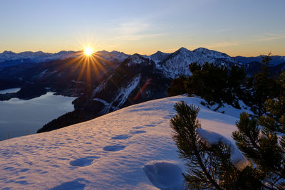 Scenic view of snow covered mountains against sky during sunset