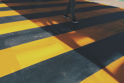 Low section of person on yellow zebra crossing