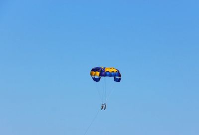 Low angle view of person against clear blue sky