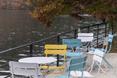 Empty chairs and tables at the lakeside during autumn 