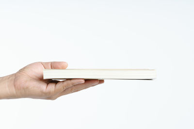 Close-up of hand holding umbrella against white background