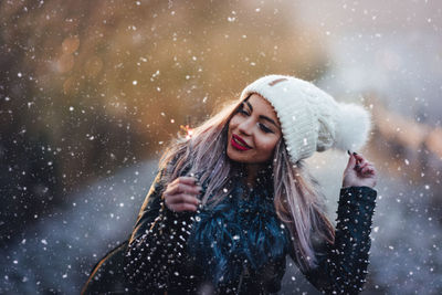 Portrait of smiling young woman in snow