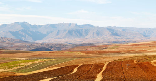 Scenic view of field and mountains against sky