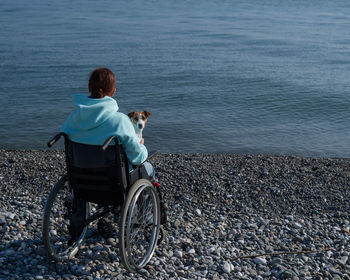 Rear view of woman with bicycle on beach