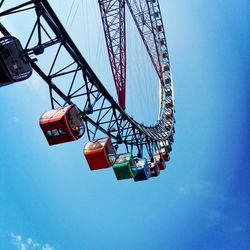 Low angle view of ferris wheel against blue sky