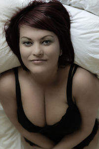 Portrait of beautiful young woman lying in bed