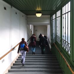 Rear view of people walking on staircase