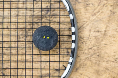 Close-up of squash ball on racket