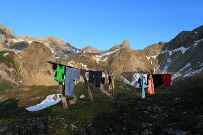 Laundry hanging from clothesline by european alps against clear sky