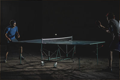 Male friends playing table tennis