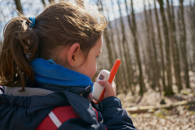 Cute girl talking on the radio while walking in the woods on winter