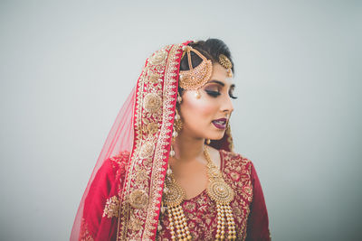 Portrait of smiling young woman against gray background