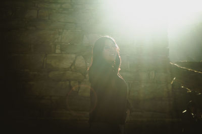 Cute girl smiling at the camera with a sunlight behind