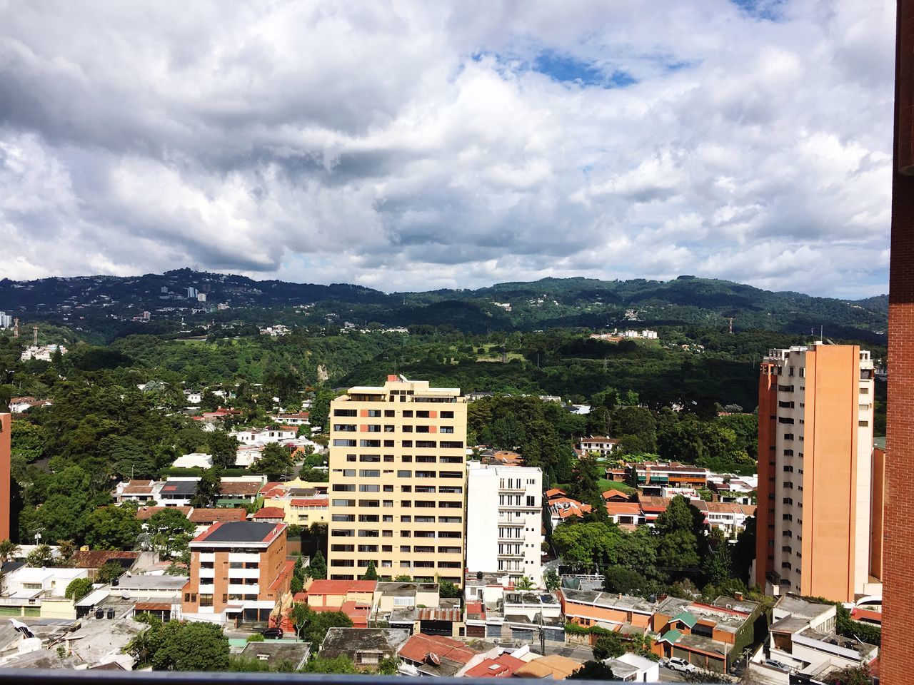 VIEW OF CITYSCAPE AGAINST CLOUDY SKY