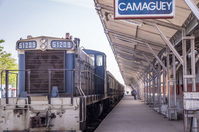 Information sign on railroad tracks against sky