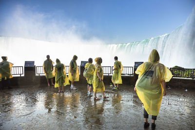 Rear view of people on wet glass during rainy season