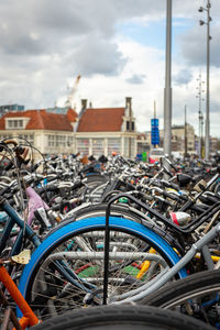 Close-up of bicycles parked in city against sky